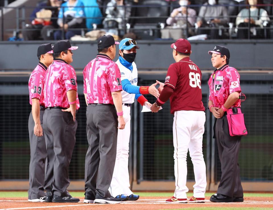 　メンバー表を交換し、楽天・三木監督（右から２人目）と握手を交わす新庄監督（中央）＝撮影・中島達哉