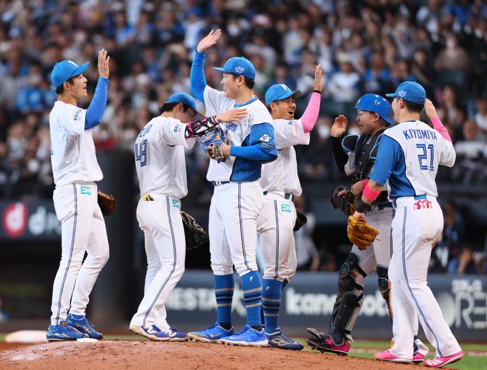 　来日初完封勝利をあげ、ナインとタッチを交わす古林（中央左）＝撮影・中島達哉