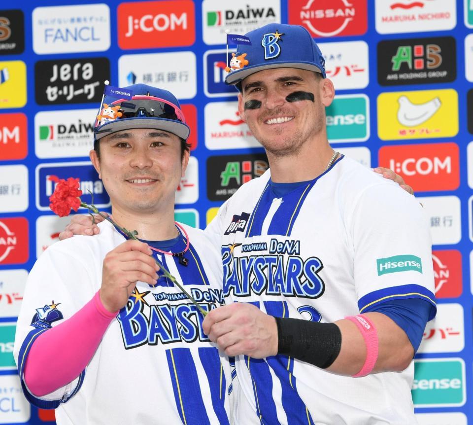 　カーネーションを手ににっこりのオースティン（右）と佐野（撮影・佐藤厚）