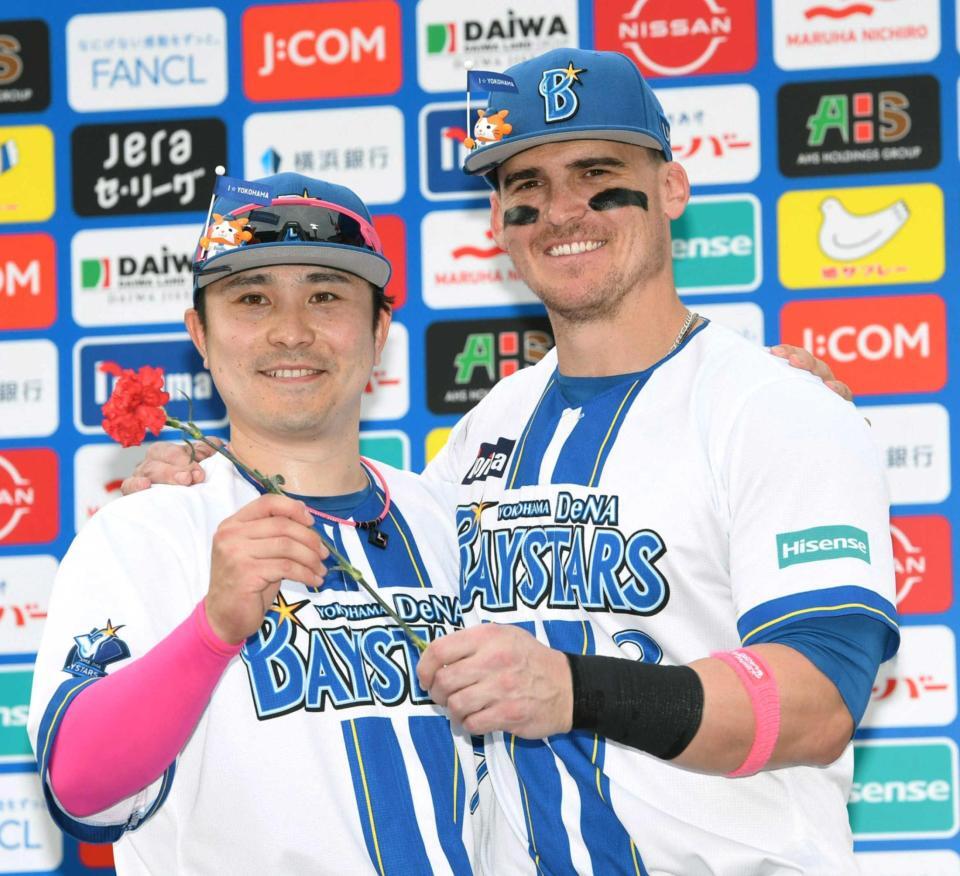 　カーネーションを手に笑顔を見せる佐野（左）とオースティン（撮影・佐藤厚）