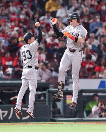 　８回、同点２ランを放ち、ジャンプして松本コーチ（左）とタッチをするキャベッジ＝撮影・市尻達拡