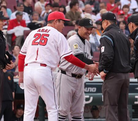 　審判団と握手を交わす新井監督と阿部監督（撮影・市尻達拡）