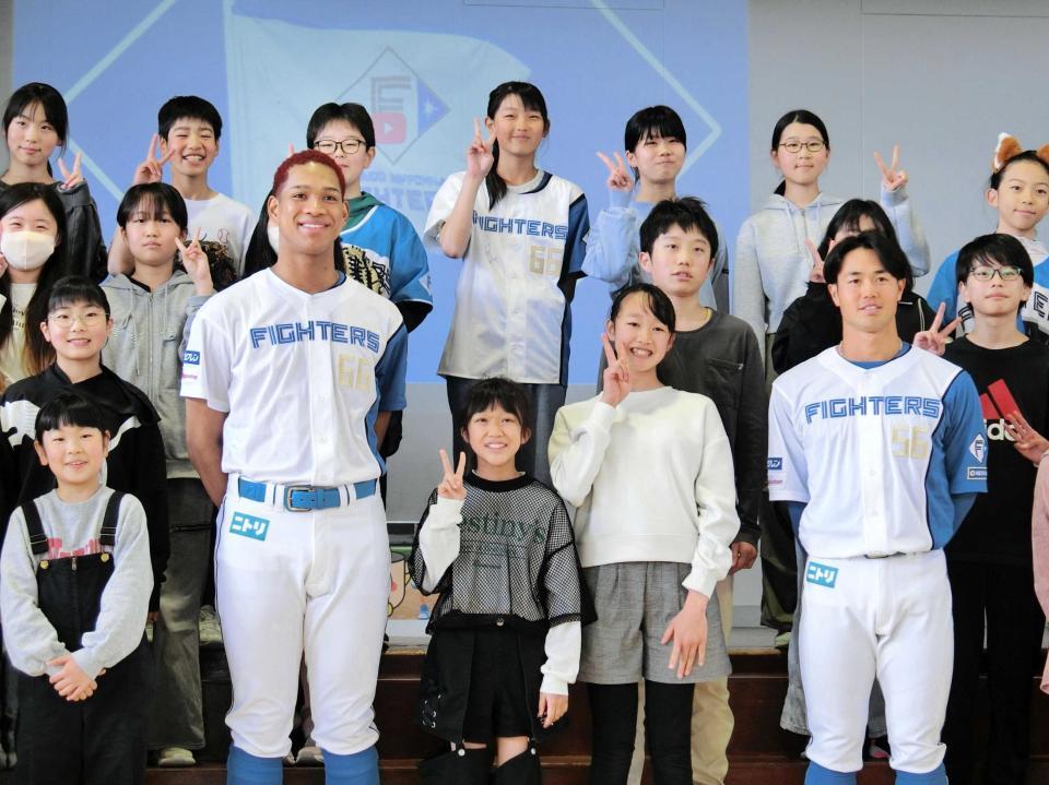 　小学校訪問で児童と記念撮影する万波（左）と細川