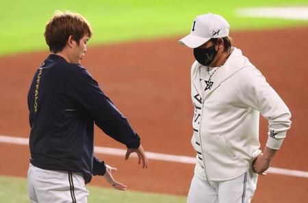 　試合前、オリックス・九里（左）とスクイズのシーンの話をする新庄監督（撮影・中島達哉）