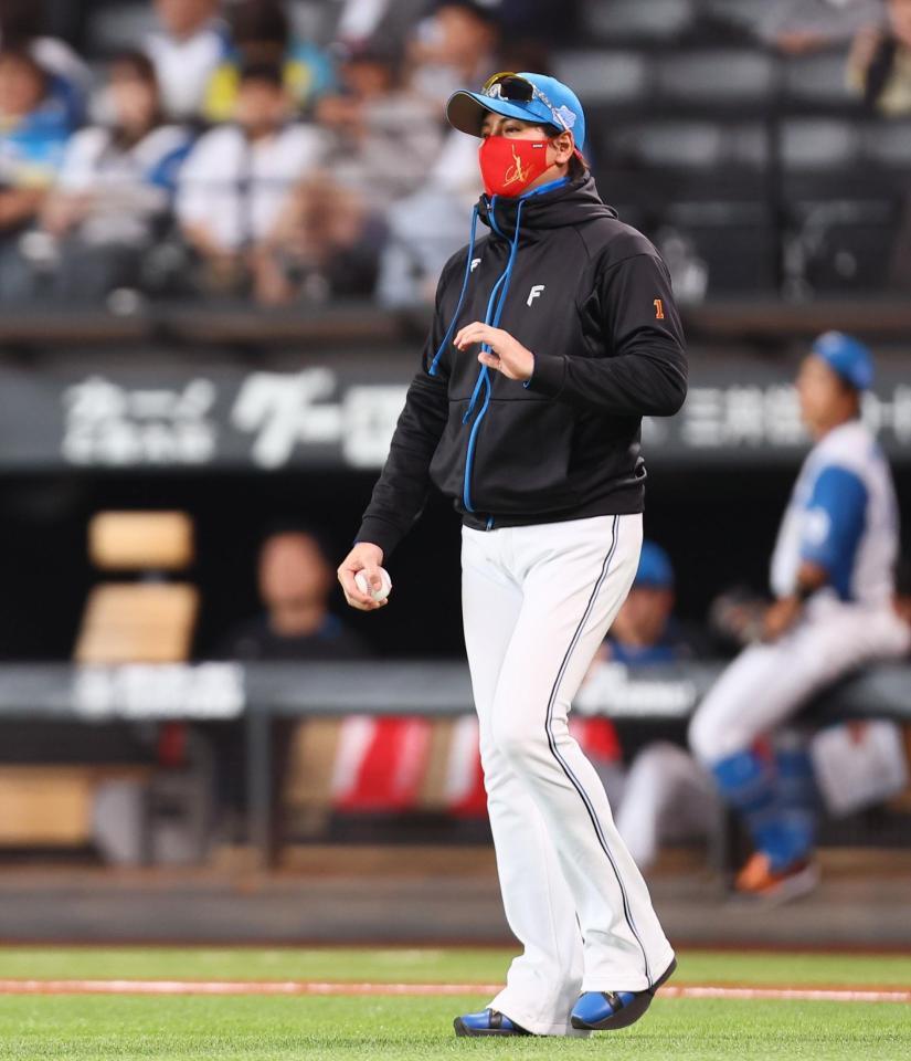 　８回、河野の交代を告げにマウンドに向かう新庄監督（撮影・中島達哉）