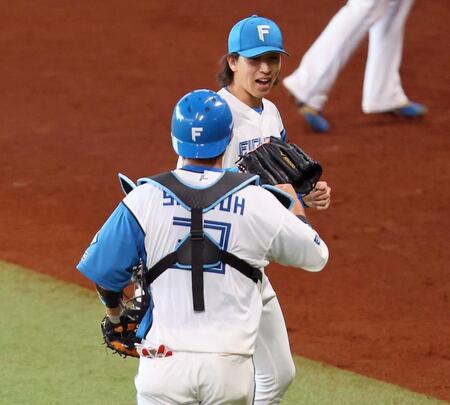 　６回を無失点に抑え、進藤（手前）とタッチを交わす細野（撮影・中島達哉）