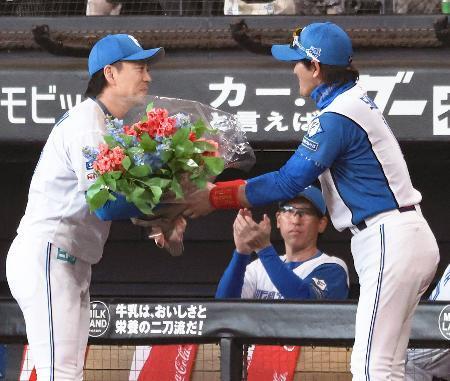 　連続救援登板のプロ野球記録を塗り替え、新庄監督（右）から花束を贈られる日本ハム・宮西＝エスコンフィールド