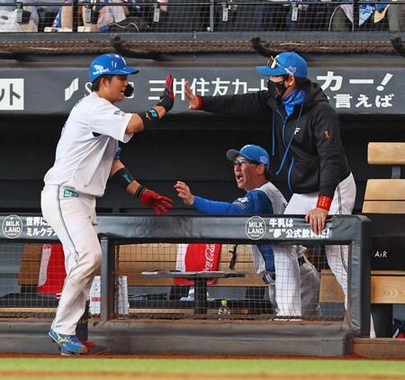 　７回、送りバントを決めた進藤（左）を迎える新庄監督（右）＝撮影・中島達哉