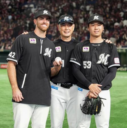 　来日初勝利のサモンズ（左）とプロ初セーブを挙げた木村（右）をたたえるロッテ・吉井監督＝東京ドーム