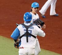 　６回を無失点に抑え、進藤（手前）とタッチを交わす細野（撮影・中島達哉）