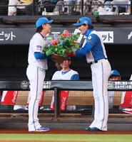 　８８０試合連続救援登板の日本記録を達成した宮西（左）に花束を手渡す新庄監督（撮影・中島達哉）