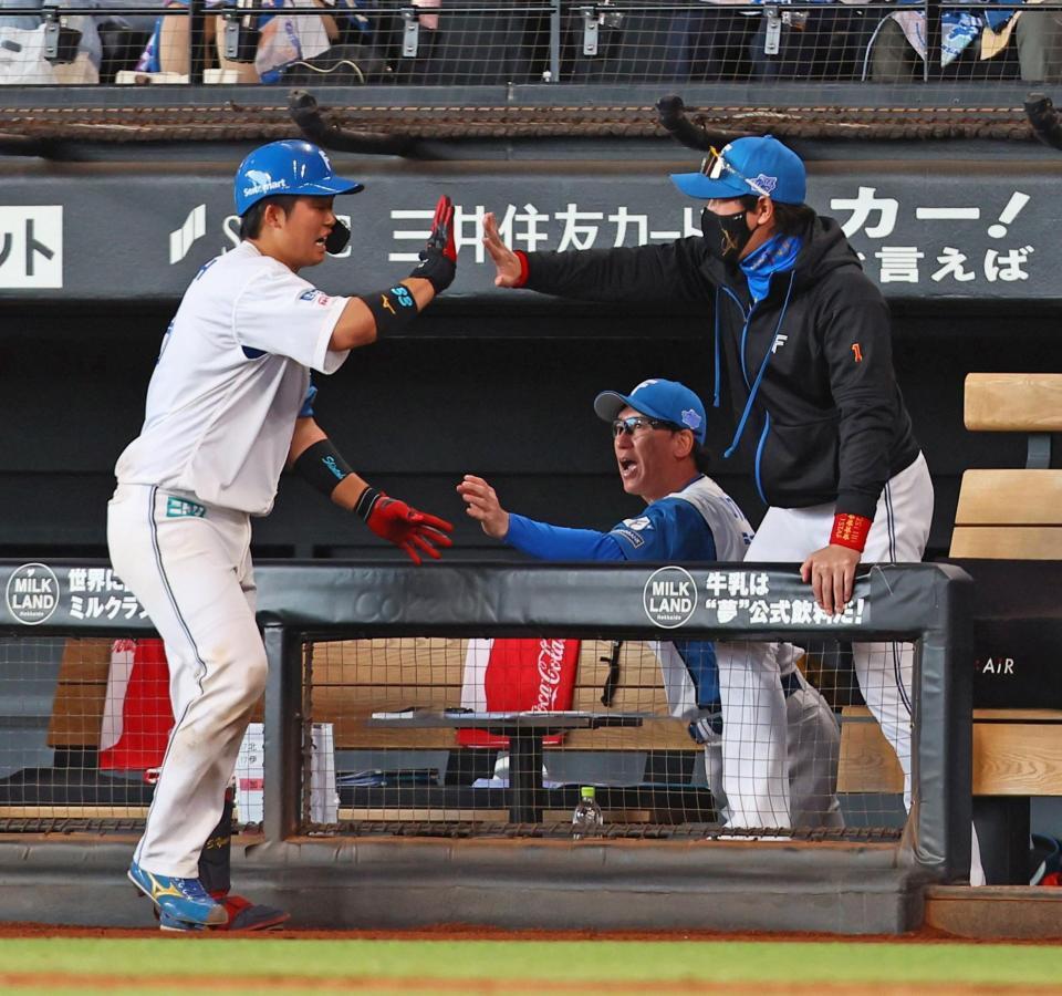 　７回、送りバントを決めた進藤（左）を迎える新庄監督（右）＝撮影・中島達哉