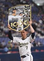 　通算１０００試合出場を達成し、記念ボードを掲げる西川（撮影・西田忠信）