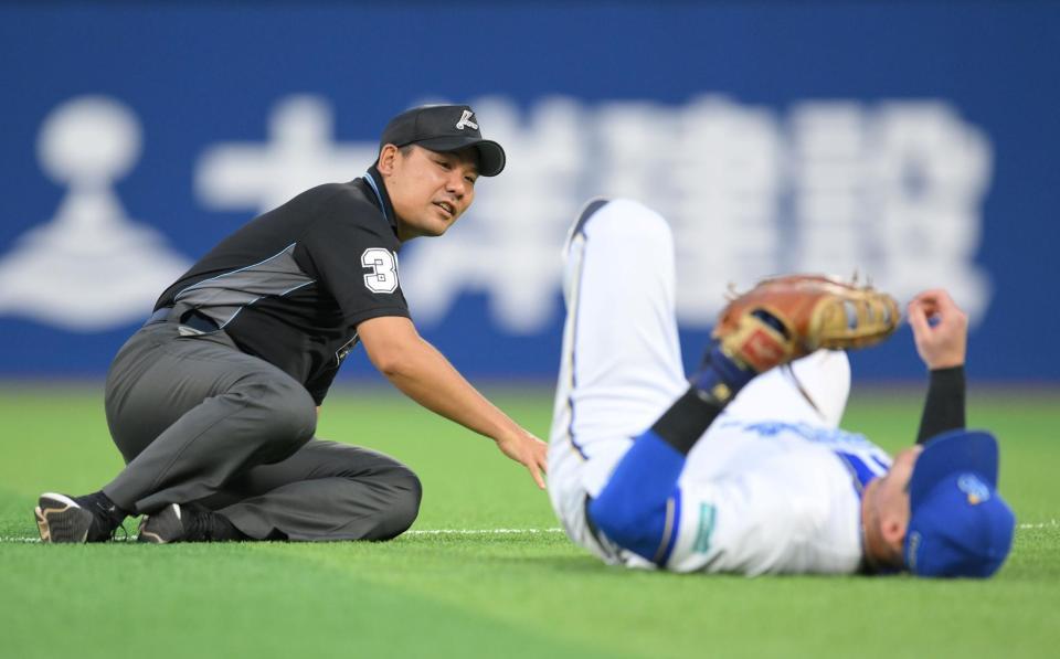 　４回、宇佐見の打球を追った一塁手のオースティン（右）と交錯し、倒れ込む市川審判員（撮影・伊藤笙子）