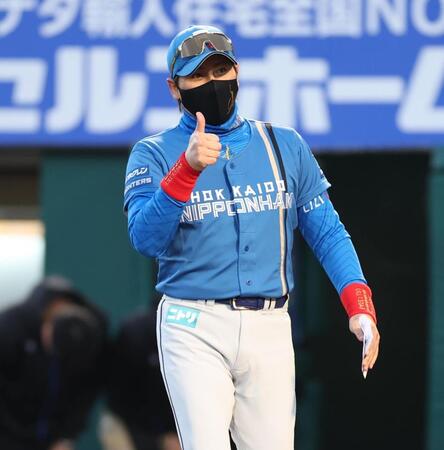 　サムアップでメンバー表交換に向かう新庄監督（撮影・金田祐二）