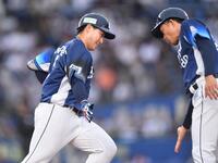 　１回、先制の左越えソロを放ち、大引コーチ（右）とタッチを交わす渡部聖（撮影・開出牧）