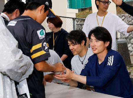 　オリックス戦が中止となり、訪れたファンにサインするソフトバンク・周東（右端）ら＝リブワーク藤崎台