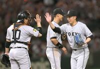 　プロ初完封で３勝目を挙げ、甲斐（左）とタッチを交わす赤星＝撮影・西岡正