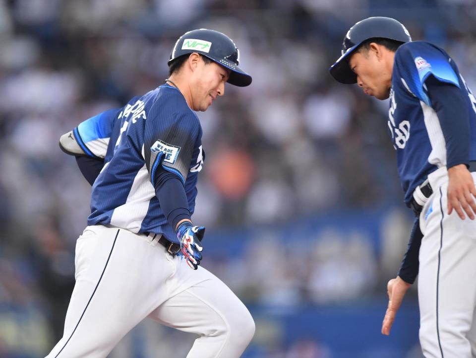 　１回、先制の左越えソロを放ち、大引コーチ（右）とタッチを交わす渡部聖（撮影・開出牧）