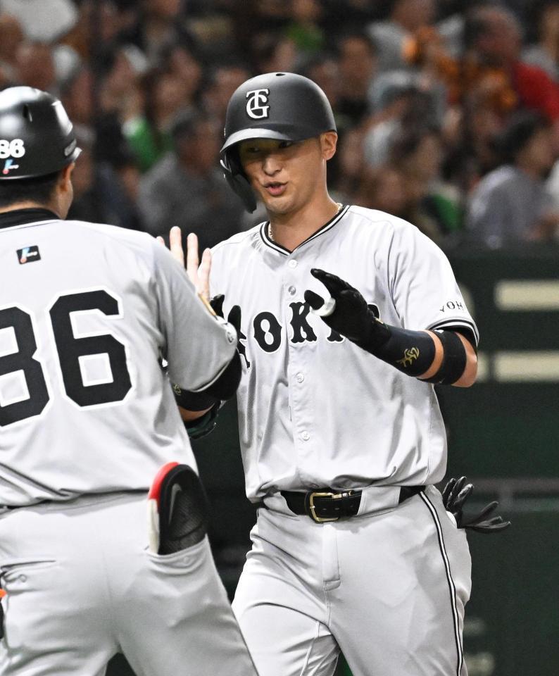 　３回、先制の本塁打を放ち、古城コーチ（左）に迎えられる吉川