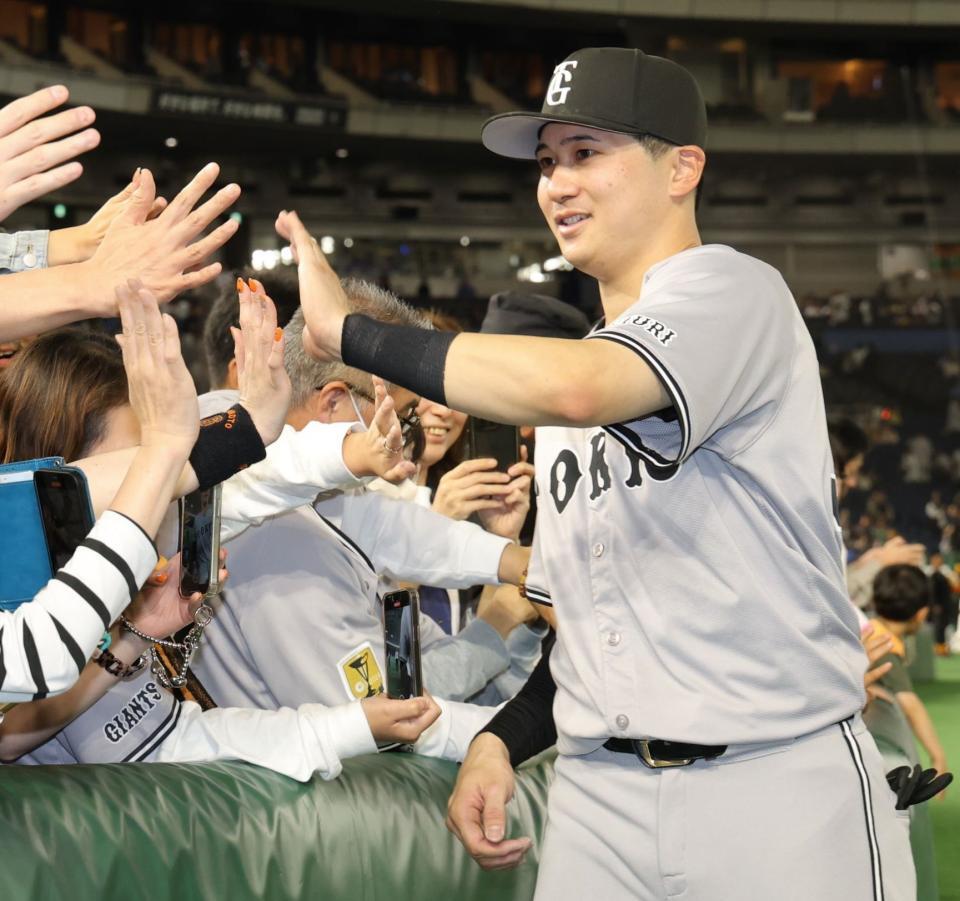 　ファンとタッチを交わす泉口（撮影・西岡正）