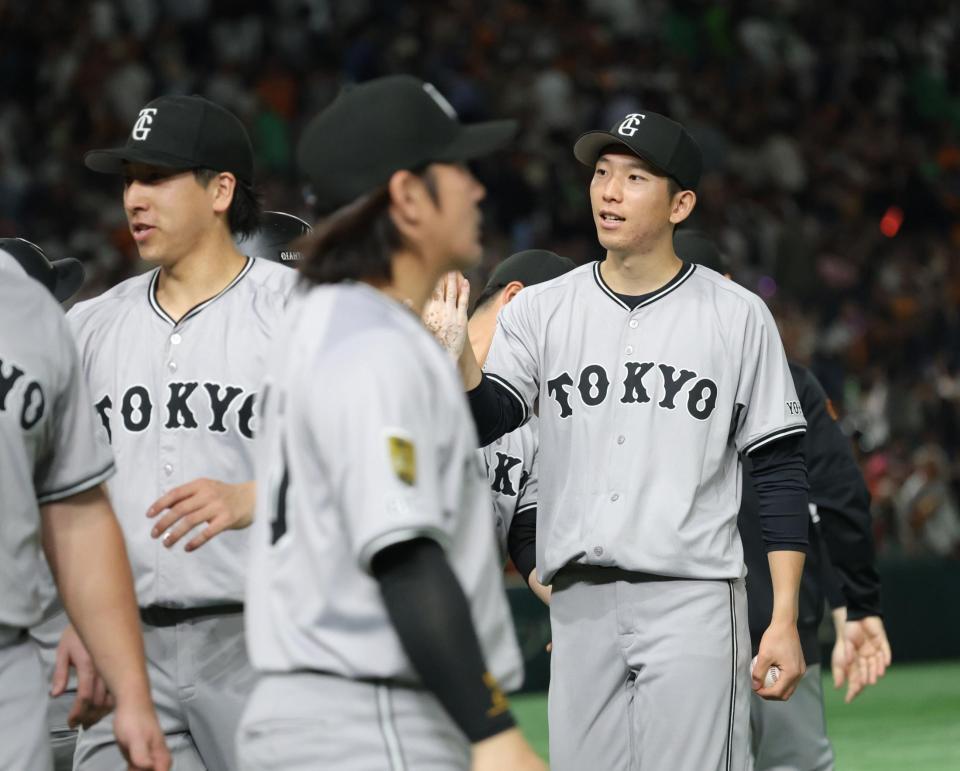 　今季初勝利を挙げ、ナインとタッチを交わす戸郷（撮影・西岡正）