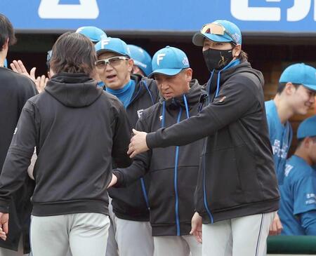 　引き分けに持ち込み、ナインを迎える新庄監督（右）＝撮影・金田祐二