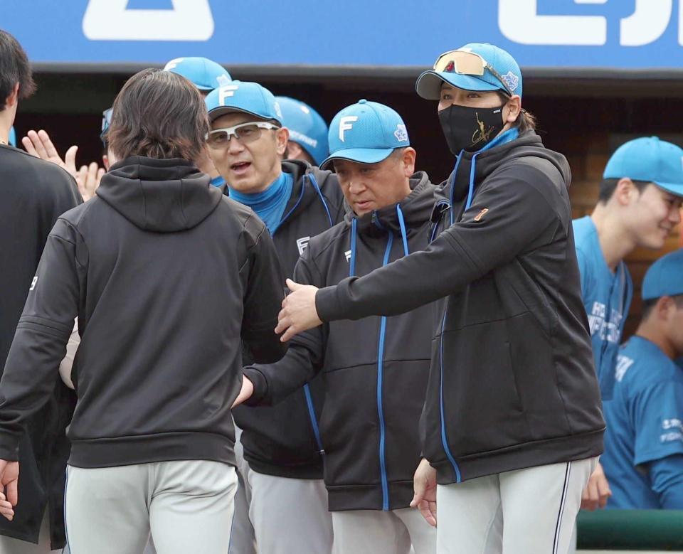 　引き分けに持ち込み、ナインを迎える新庄監督（右）＝撮影・金田祐二