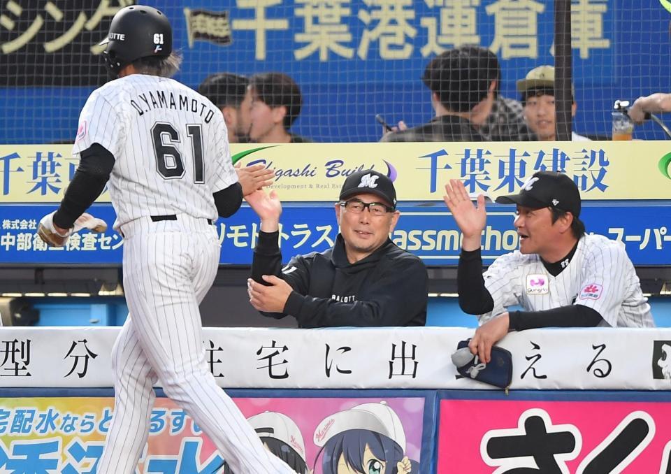 　２回、高部の右越え適時二塁打で先制のホームを踏んだ山本（６１）とタッチを交わす吉井監督（右から２人目）＝撮影・開出牧
