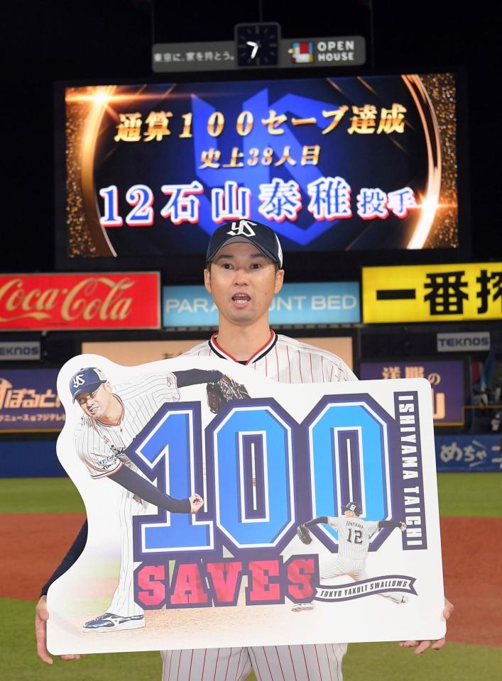 　通算１００セーブを達成し、ボードを持つ石山（撮影・佐藤厚）