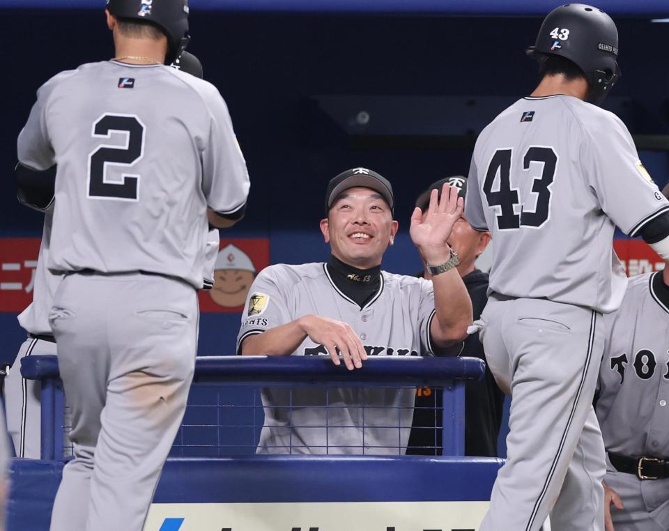 　７回表、阿部監督（中央）が生還した吉川（左）、重信（右）を笑顔で迎える