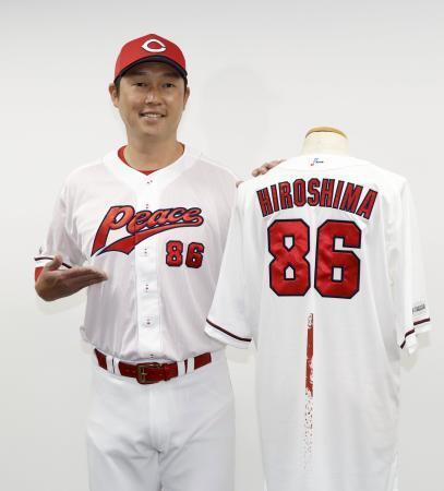 　特別ユニホームを着用し、記念写真に納まる広島・新井監督＝３１日、マツダスタジアム