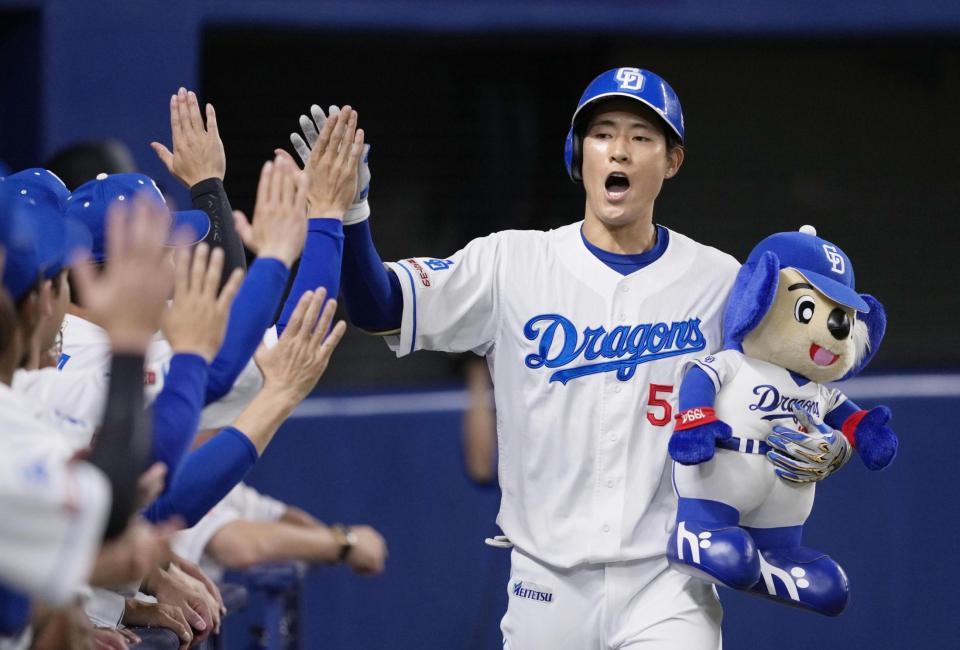 　１回、先頭打者本塁打を放ち、ナインに迎えられる中日・上林＝バンテリンドーム