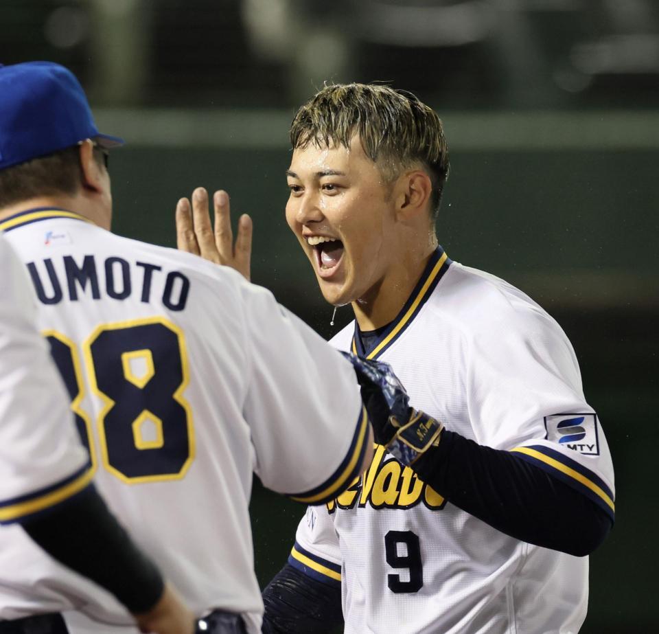 　１１回、サヨナラ本塁打を放って祝福され、笑顔を見せる野口（撮影・立川洋一郎）