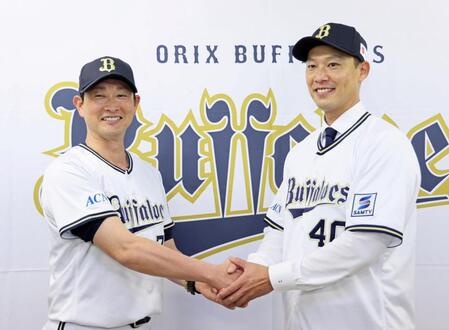 　入団会見を終えて岸田監督（左）と握手を交わす岩崎（撮影・立川洋一郎）