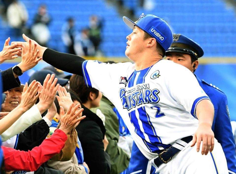 　ファンとタッチを交わす牧（撮影・佐藤厚）