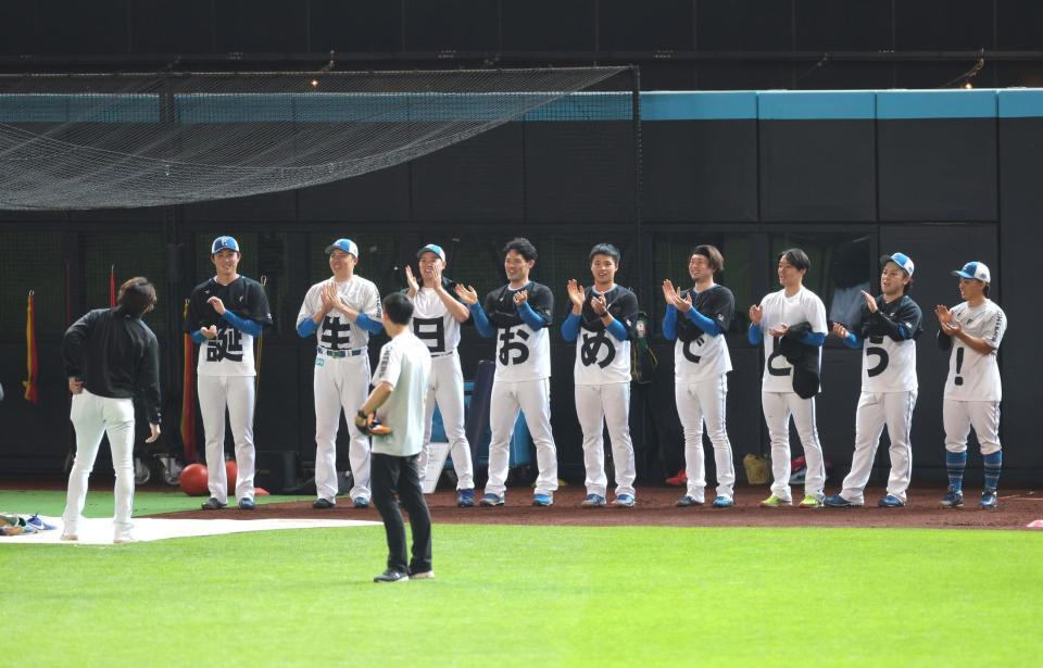 　試合前練習中、サプライズで投手陣から２日の誕生日を祝福された宮西（左）＝撮影・西岡正