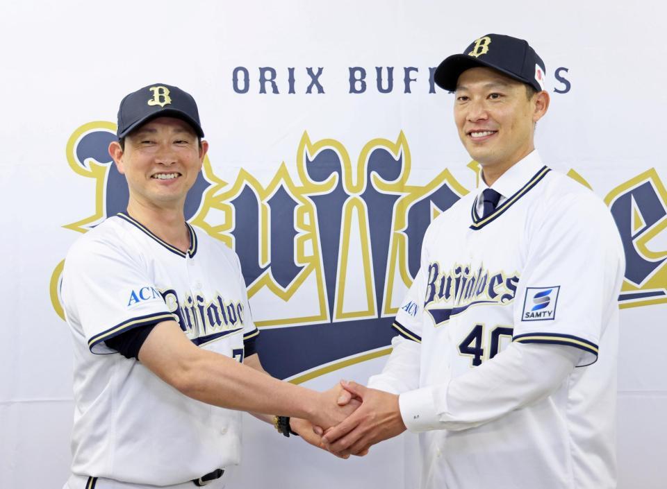 　入団会見を終えて岸田監督（左）と握手を交わす岩崎（撮影・立川洋一郎）