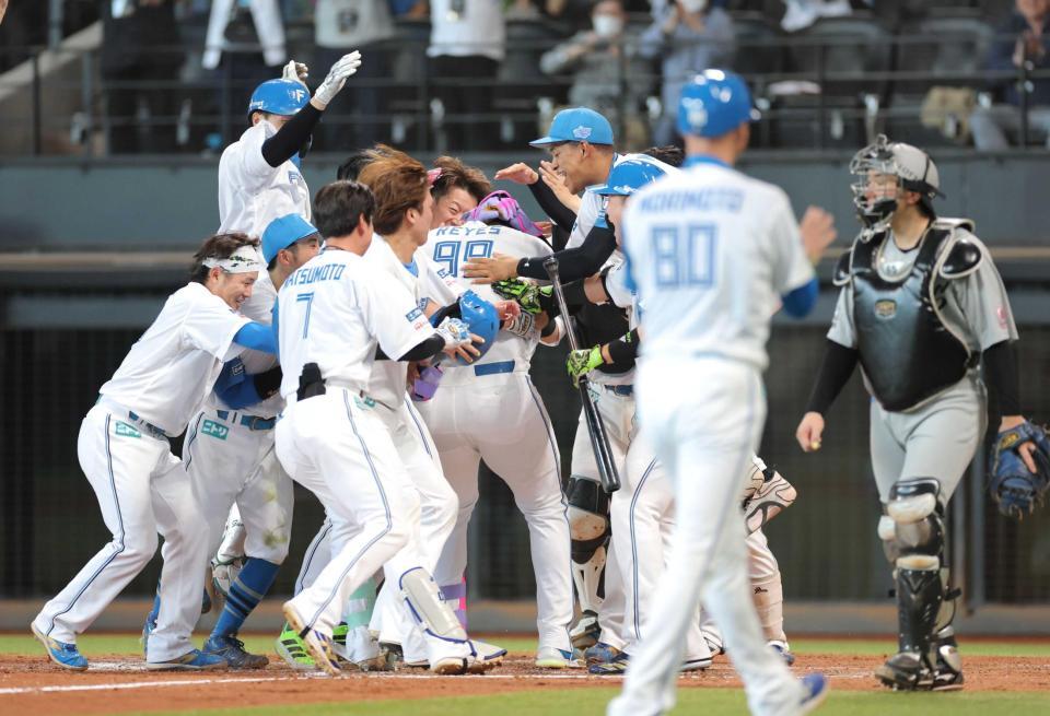 　９回、サヨナラ本塁打を放ったレイエス（９９）を祝福する日本ハムナイン（撮影・西岡正）