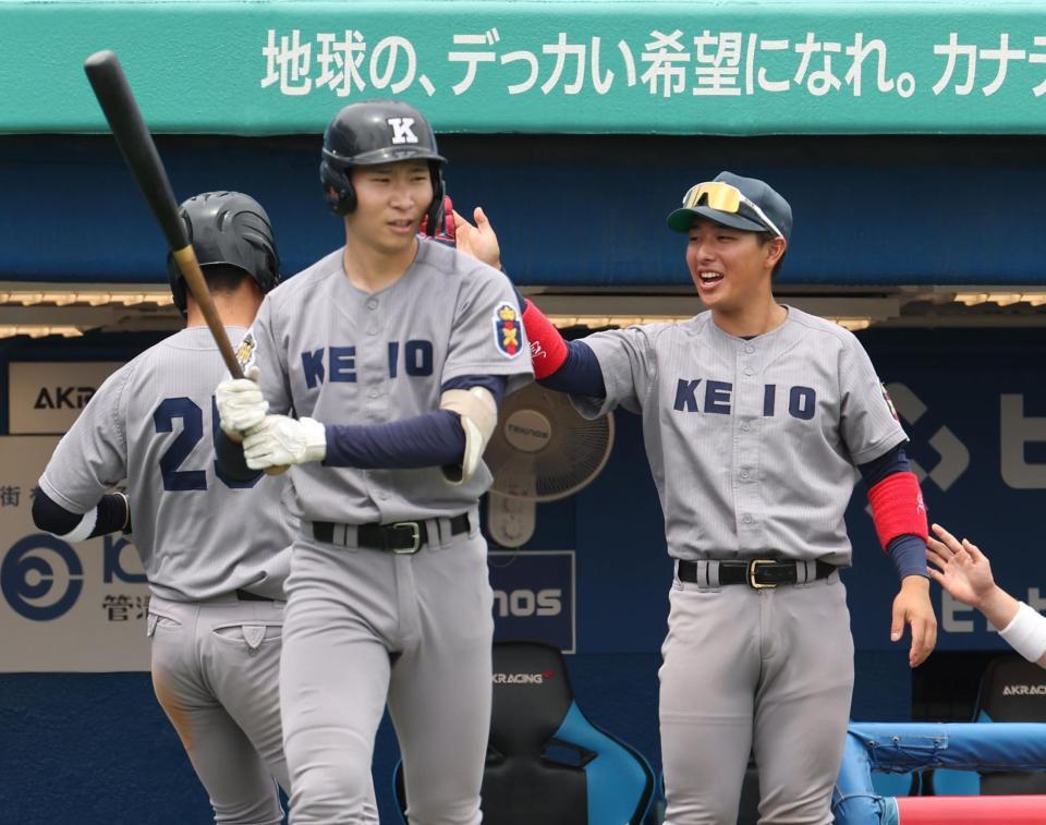 　２回、先制犠飛で生還した三塁走者・福井直を出迎える慶大・清原勝児（右）＝撮影・佐々木彰尚