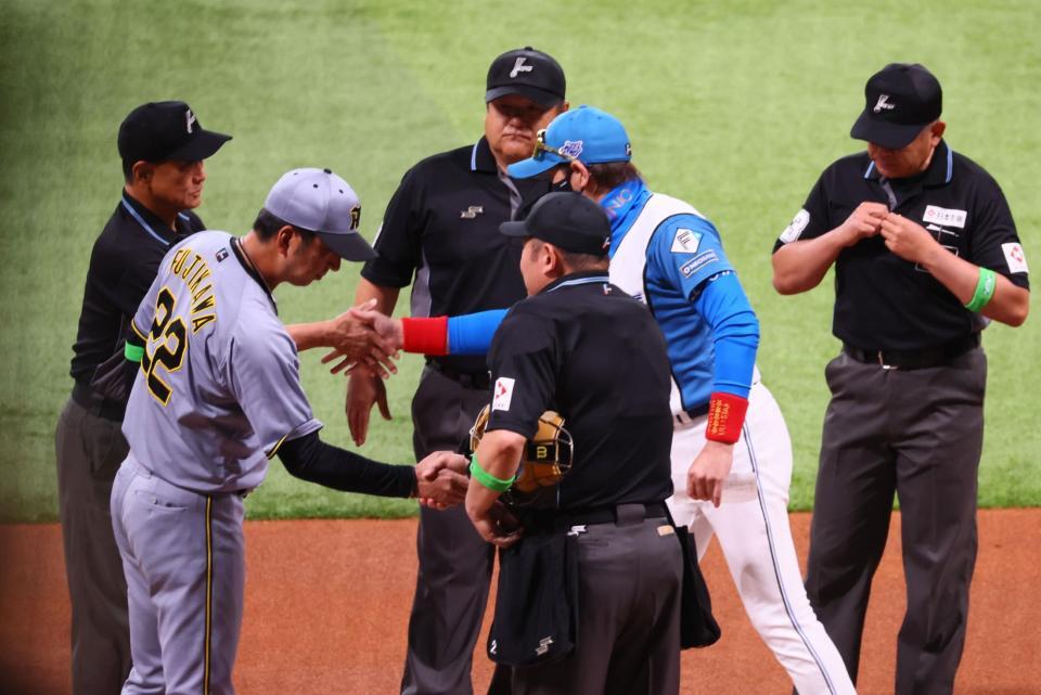 　メンバー表を交換し、審判団と握手を交わす新庄監督（右から２人目）と藤川監督（左から２人目）＝撮影・中島達哉