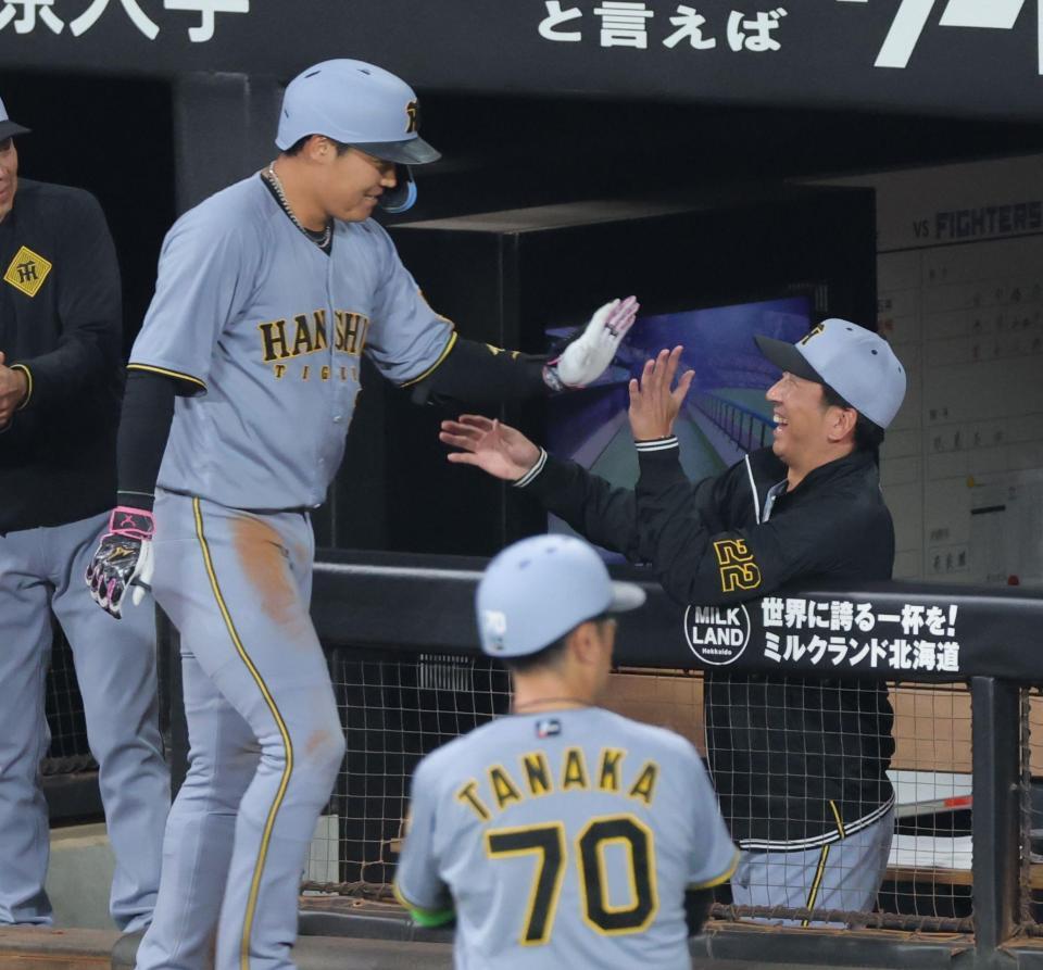 　６回、先制ソロを放ち、藤川監督（右）とタッチを交わす大山（撮影・西岡正）