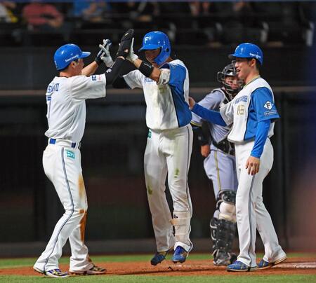 　４回、プロ初本塁打となる勝ち越し２ランを放ち、松本（左）らに迎えられる山県（中央）＝撮影・中島達哉