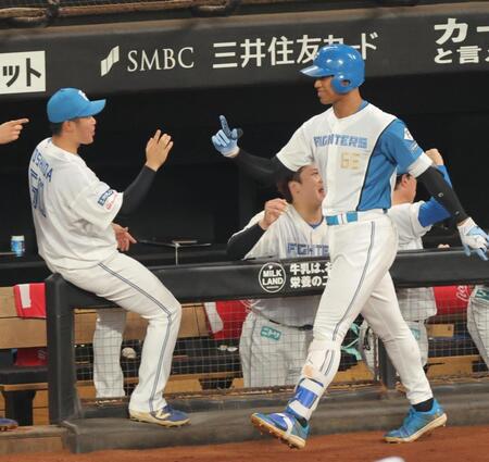 ２回、ソロを放ち、ナインとタッチを交わす万波（右）＝撮影・西岡正