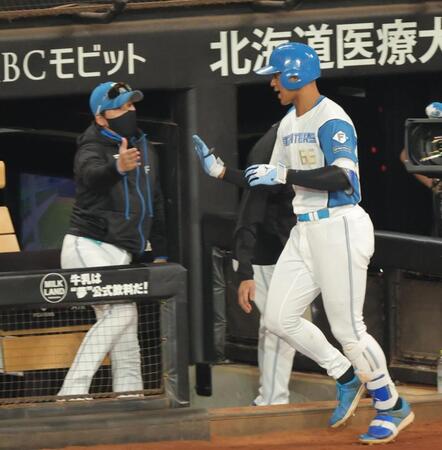 ２回、ソロを放ち、新庄監督（左）とタッチを交わす万波（撮影・西岡正）