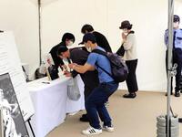 　ジャイアンツタウンに記帳所を設置、記帳し手を合わせるファン