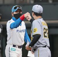 　タッチを交わす藤川監督と新庄監督（撮影・田中太一）
