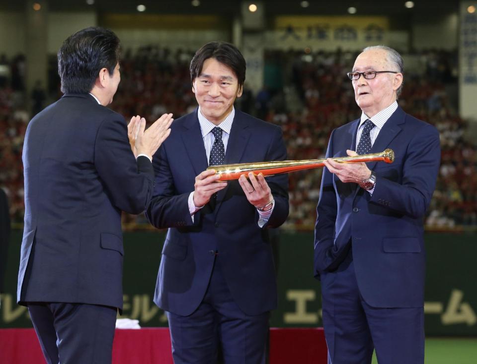 　国民栄誉賞の授与式で、安倍首相（左）から金のバットを授与される長嶋氏（右）と松井氏＝１３年５月