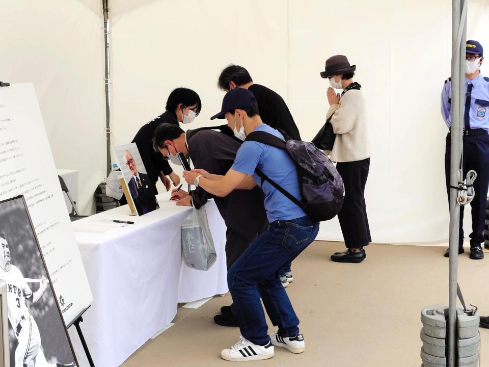 　ジャイアンツタウンに記帳所を設置、記帳し手を合わせるファン