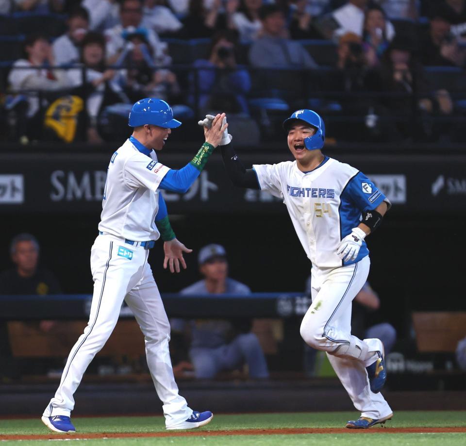 ４回、プロ初本塁打となる勝ち越し２ランを放ち、森本外野守備走塁コーチ（左）と笑顔でタッチを交わす山県（撮影・中島達哉）